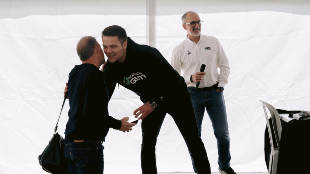 Clement Schneider hugging Frank Staffon, with Laurent Pereira in the background.